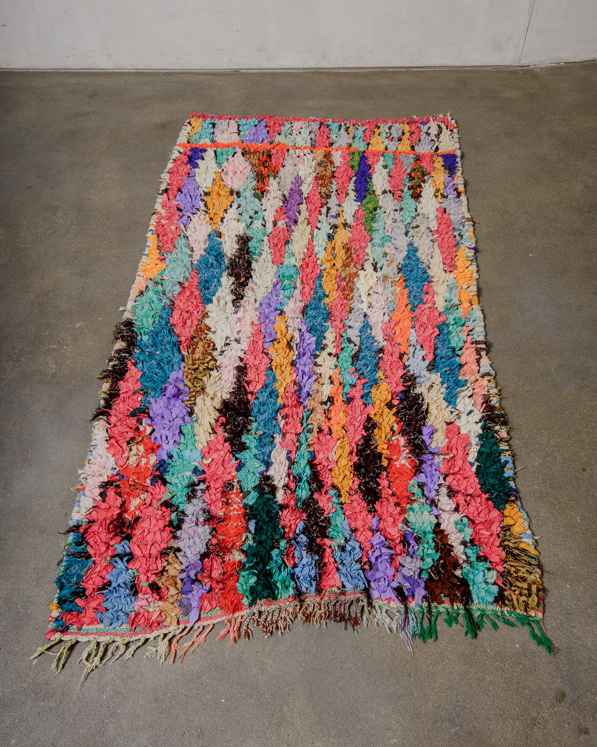 Multicoloured textured rug on a plain floor